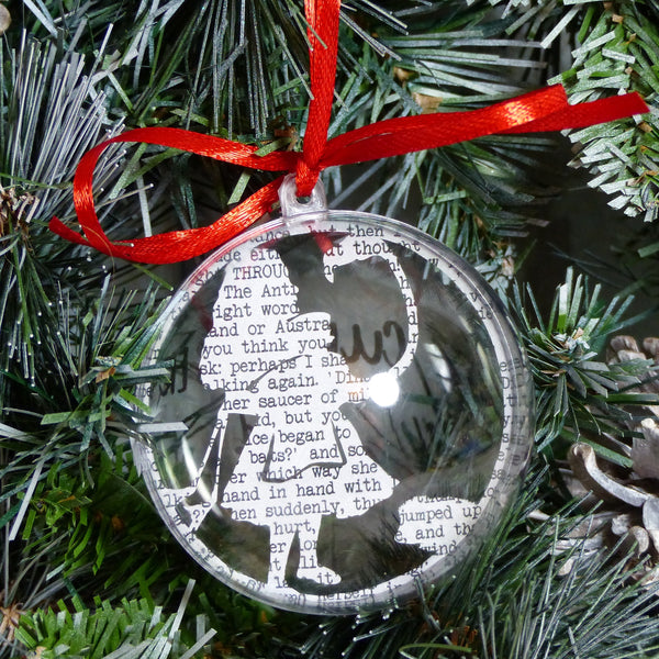 Alice holding flamingo papercut silhouette encased in plastic bauble